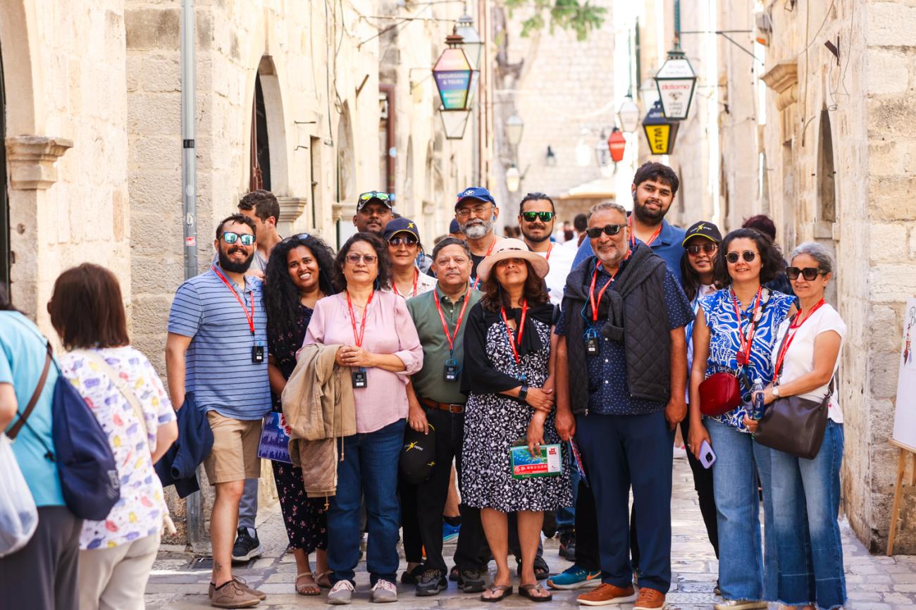 Tour group posing in a narrow stone street inside Dubrovnik Old Town, Croatia