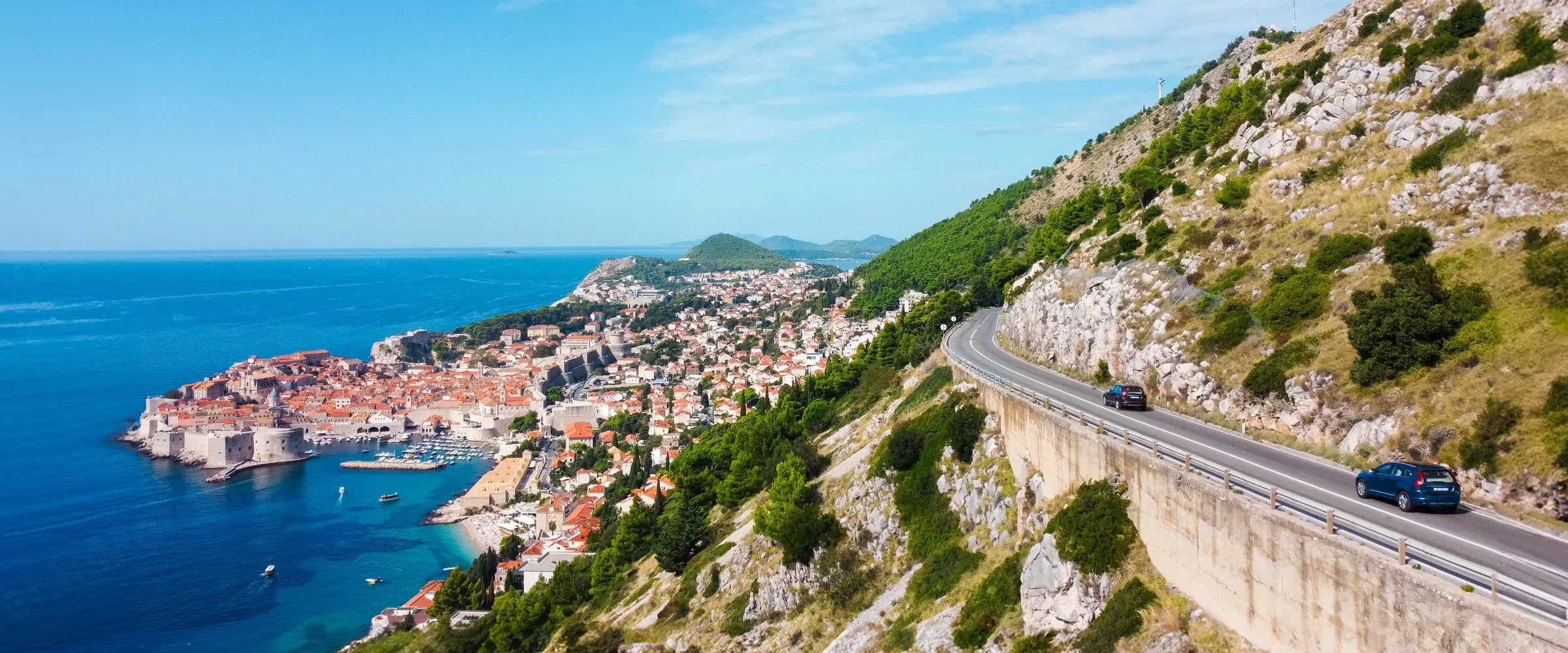 Self-drive SUV on a coastal mountain road in the Balkans