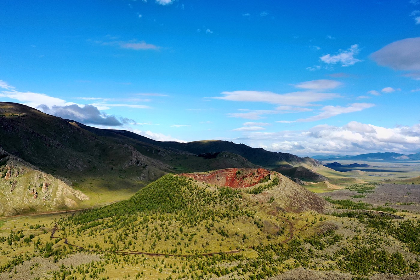 Aerial view of the extinct Khorgo Volcano crater surrounded by pine forest near Terkhiin Tsagaan Lake