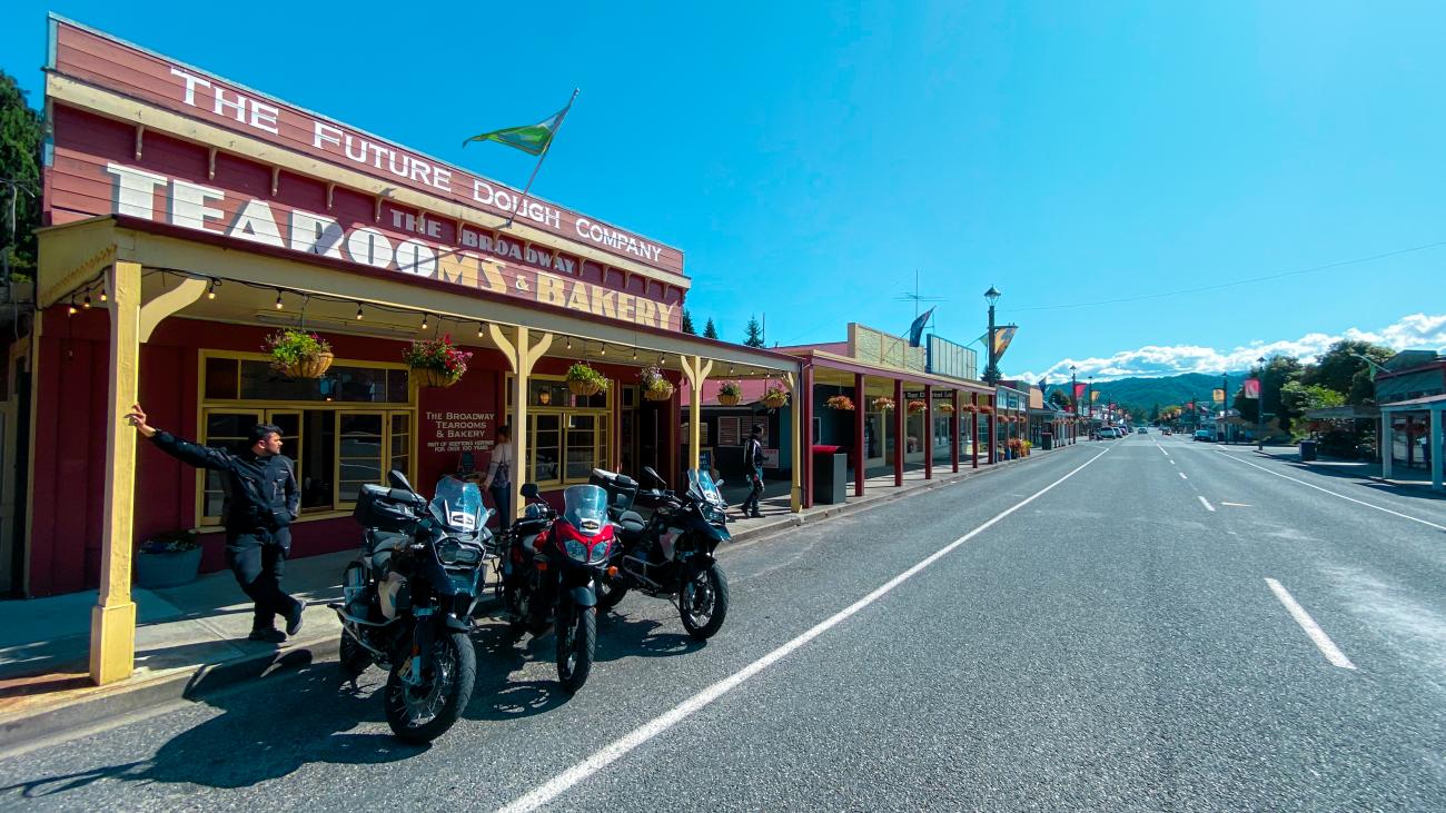 Touring motorcycles parked outside a historic Broadway Tearooms and Bakery in a charming New Zealand small town.