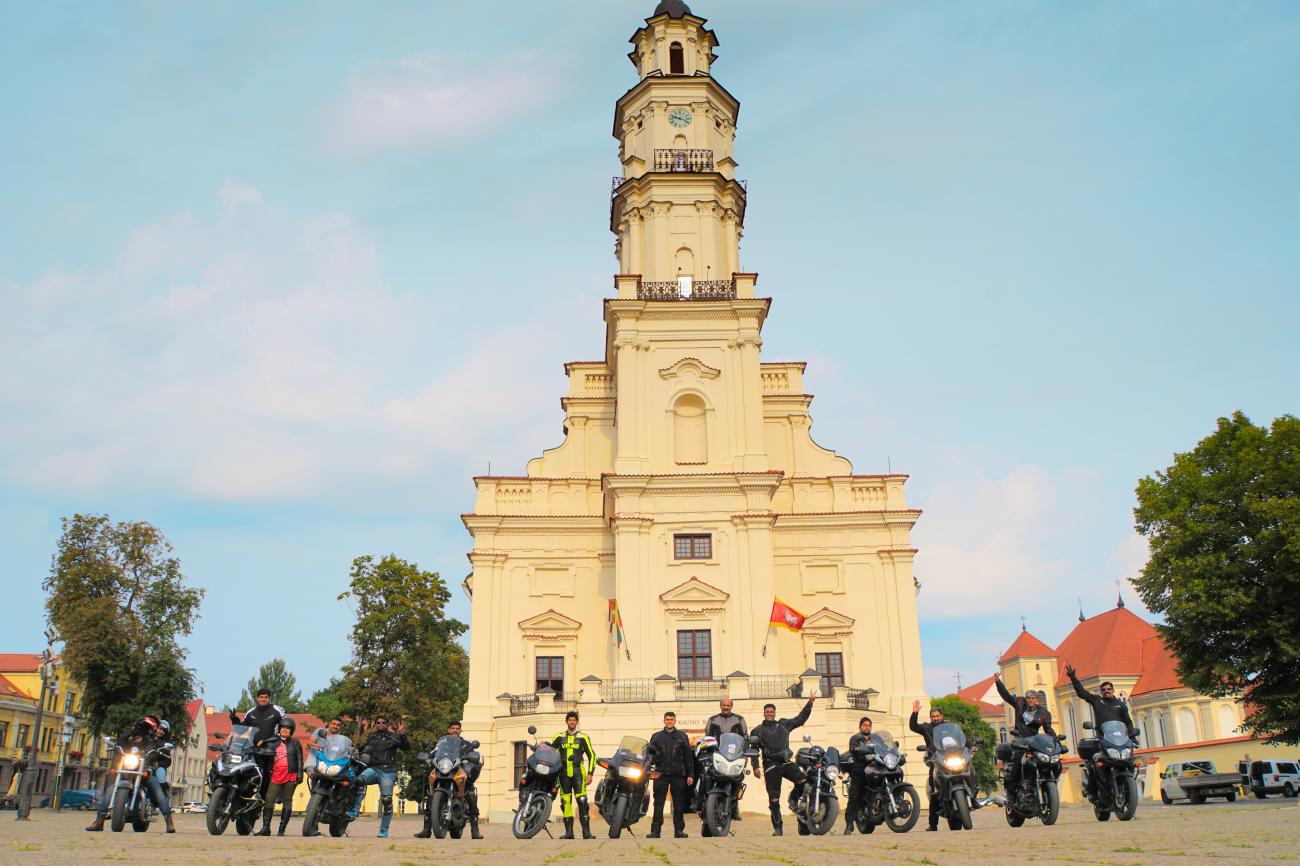 Motorcycle tour group lined up with bikes in front of Kaunas Town Hall in Lithuania.