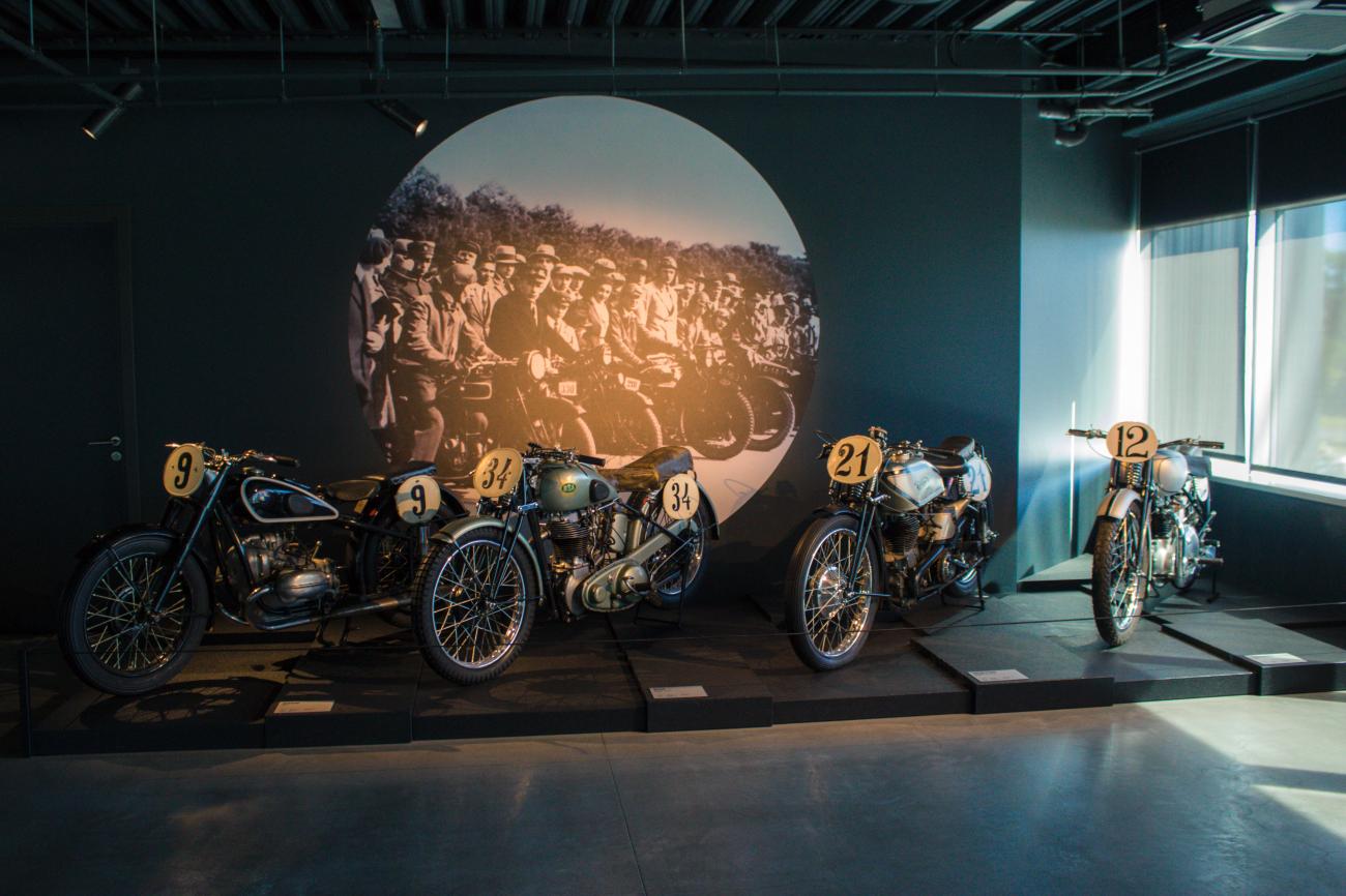 Vintage racing motorcycles on display at a Northern European motorcycle museum.