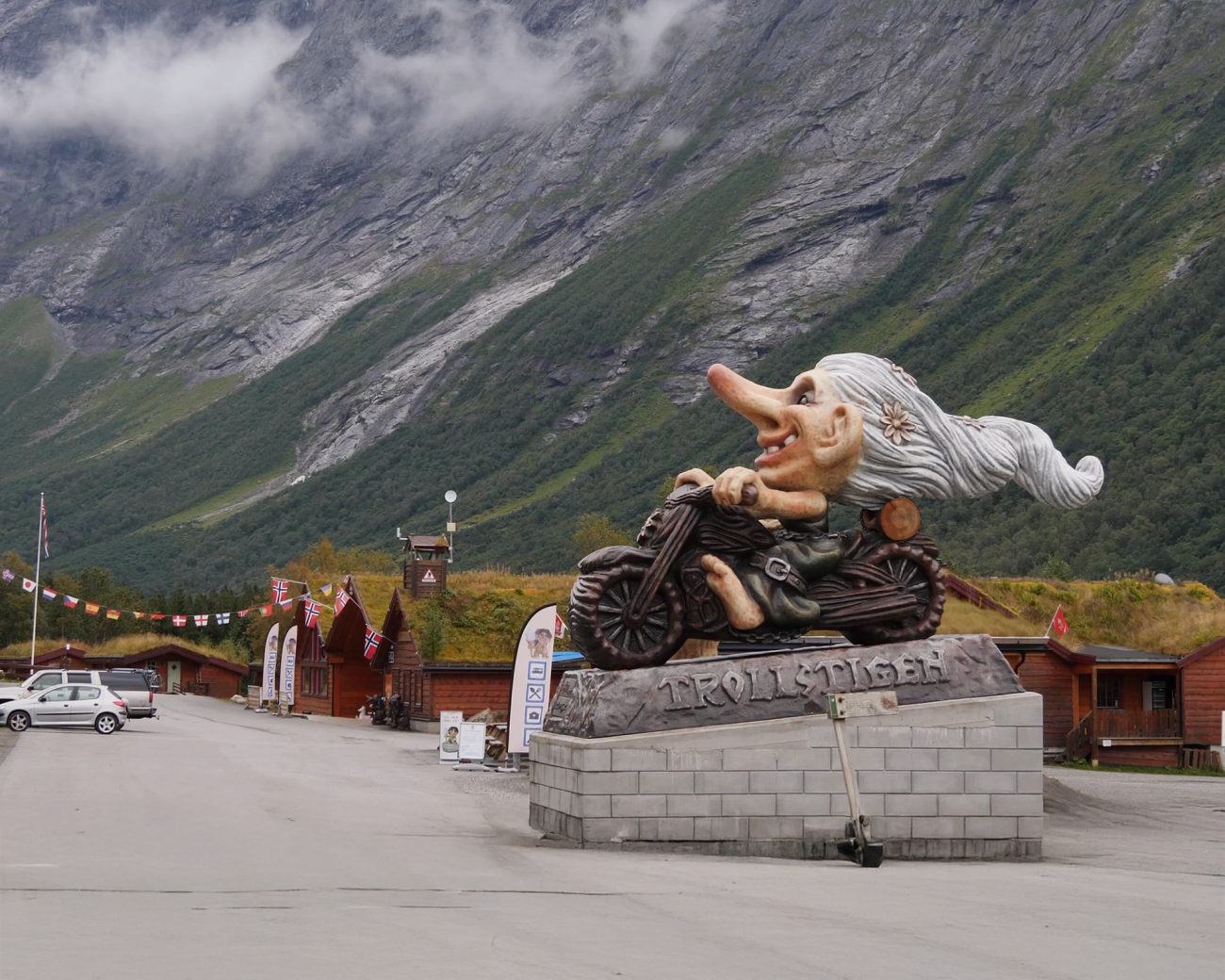 Giant troll-on-a-motorcycle statue at the Trollstigen visitor centre with steep green mountains behind.