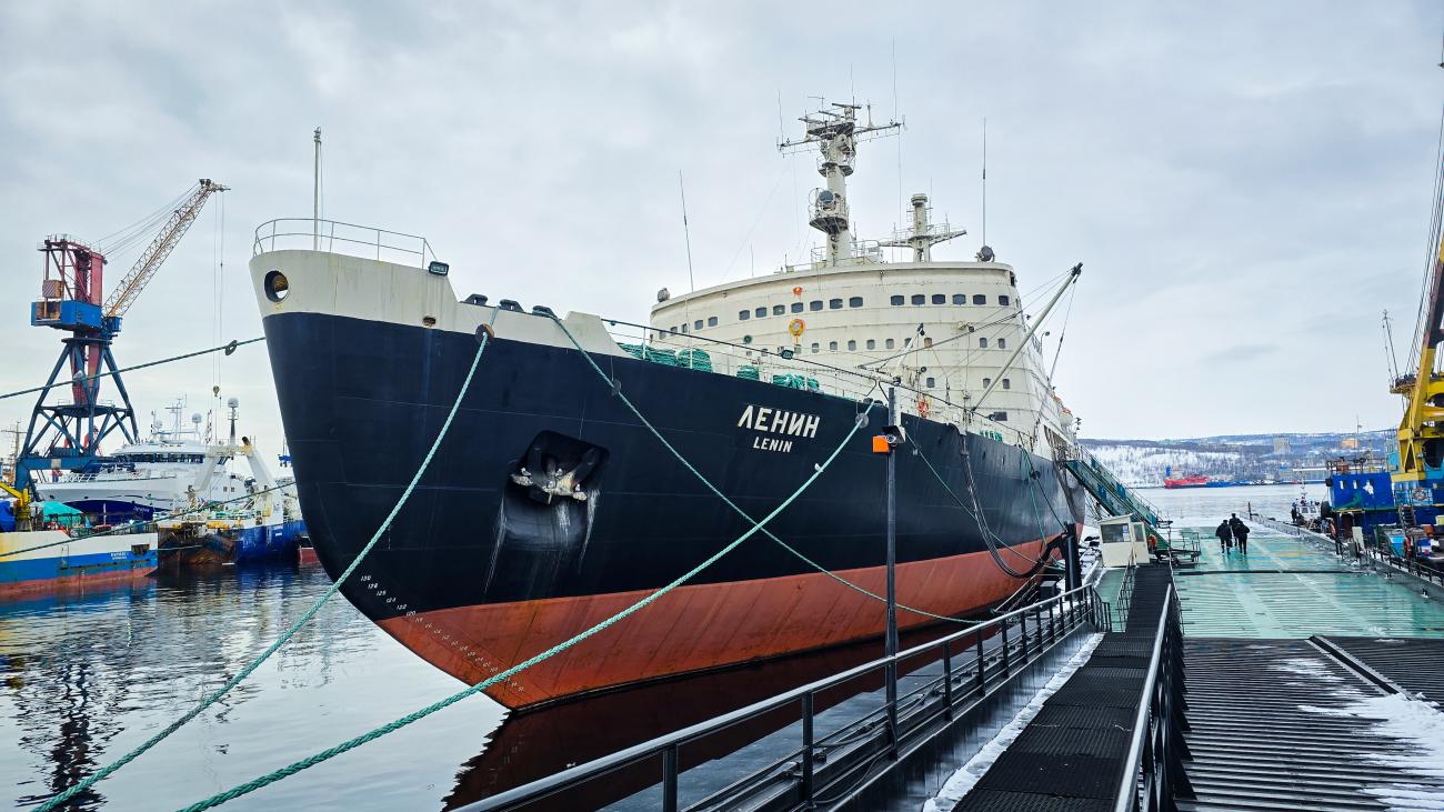 The historic Lenin nuclear-powered icebreaker docked at the port of Murmansk under overcast winter skies.