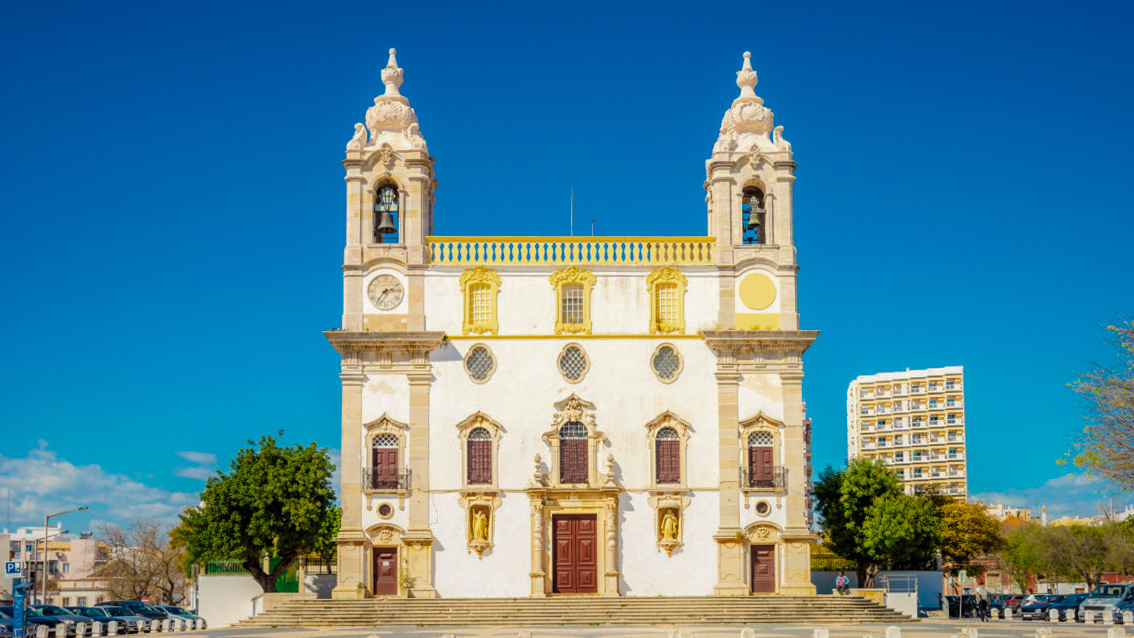 Baroque facade of the Igreja do Carmo church with twin bell towers in Faro, Portugal.